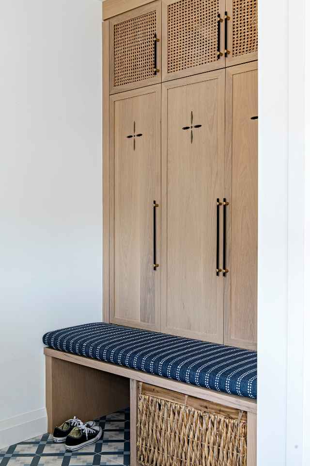 custom woodwork bench and cupboards in entryway with mosaic blue tile